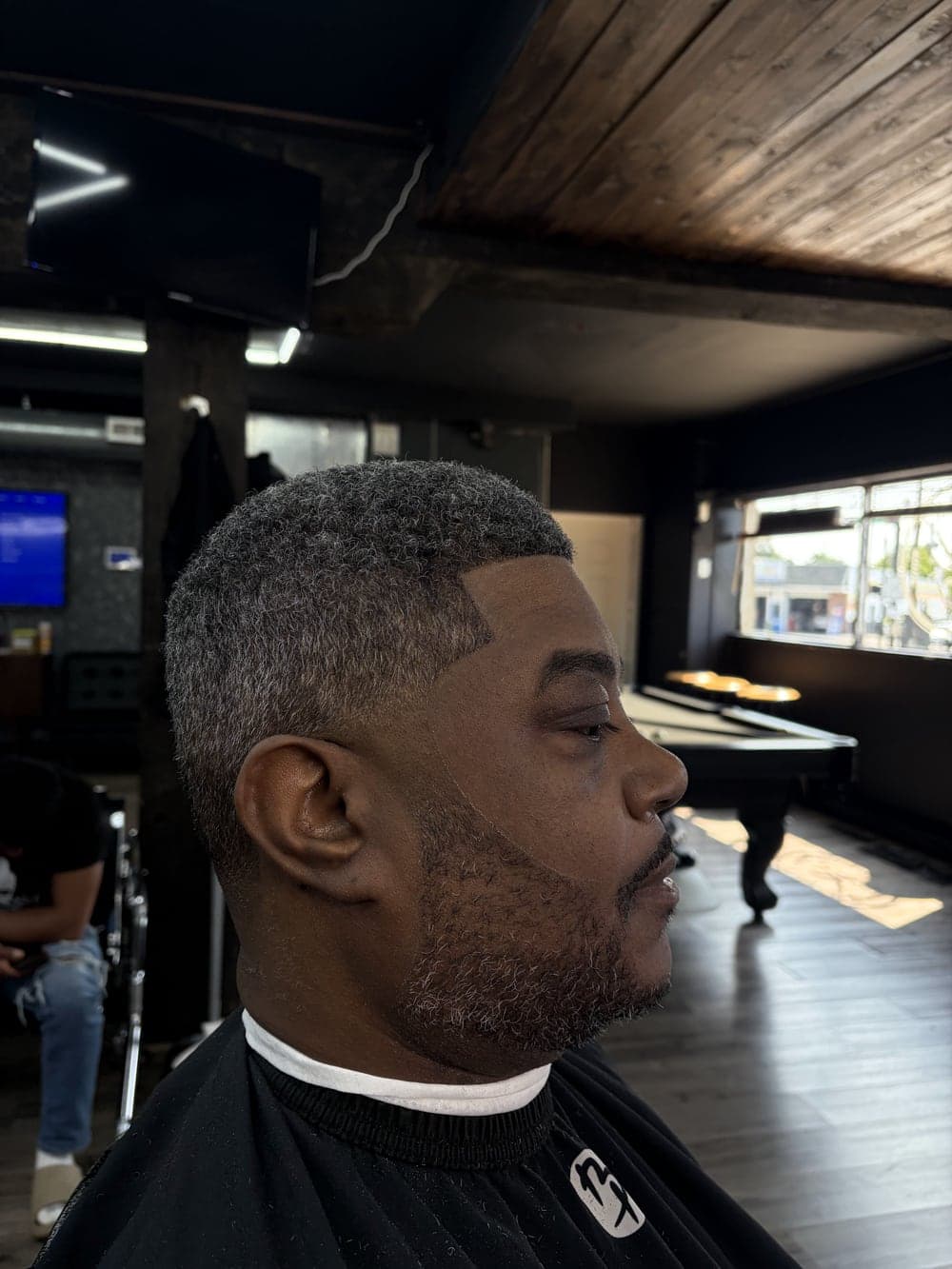 Low fade with a sharp line-up and beard blend