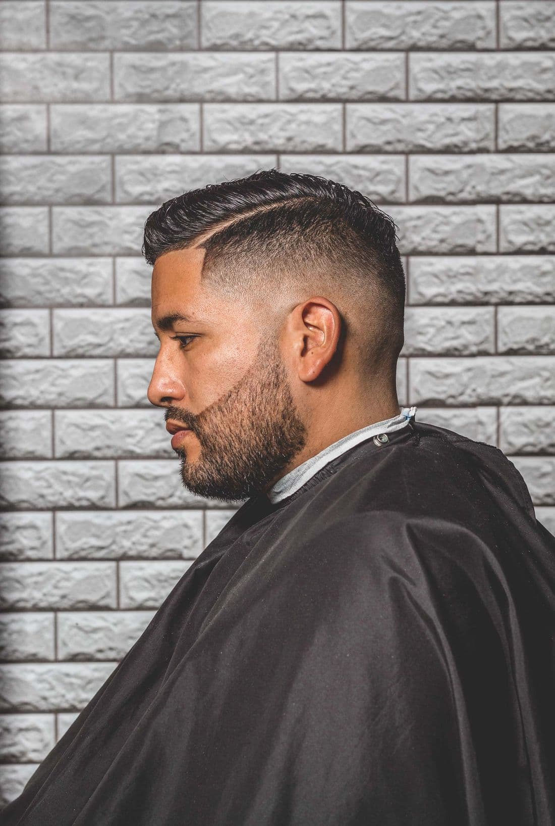 Clean fade, side profile against brick